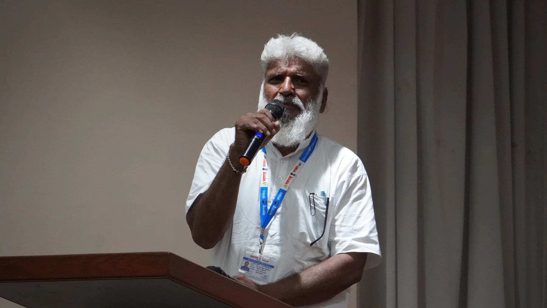 A speaker addressing the audience with a microphone on Day 2