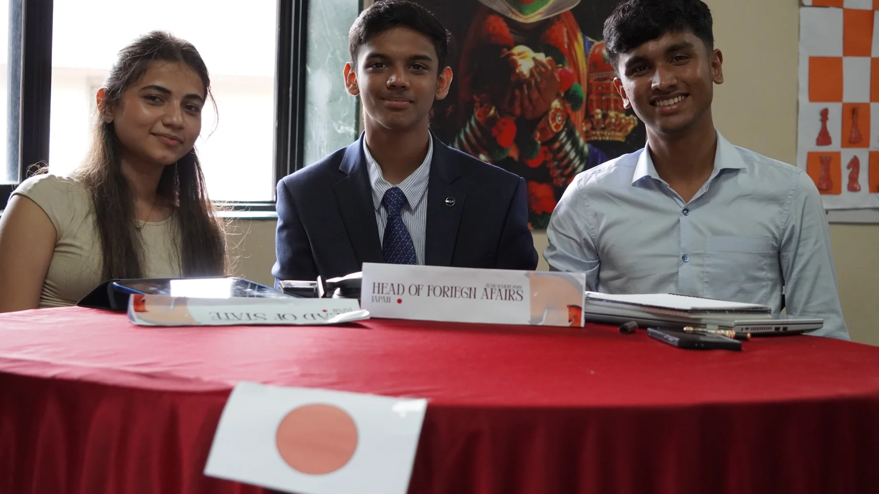Three participants seated at a delegation table on Day 2