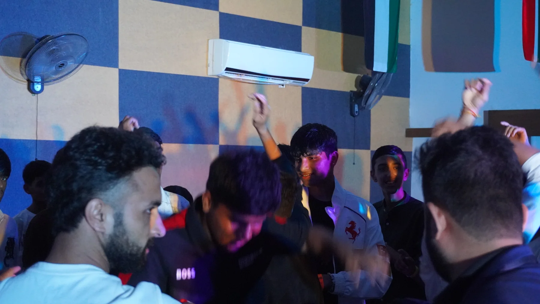 Participants dancing together under coloured lights at DJ night