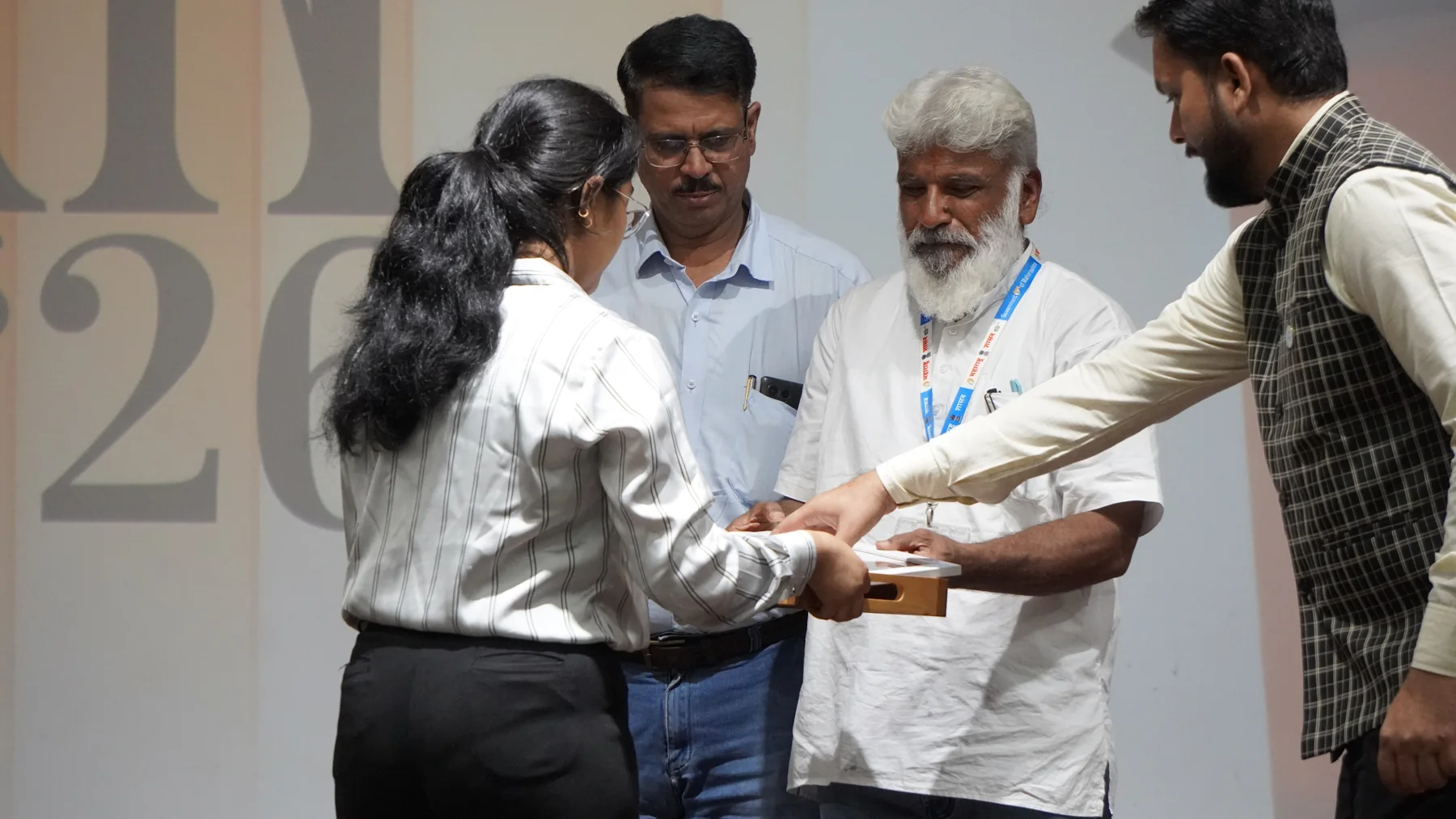 A participant receiving a presentation from the team on stage